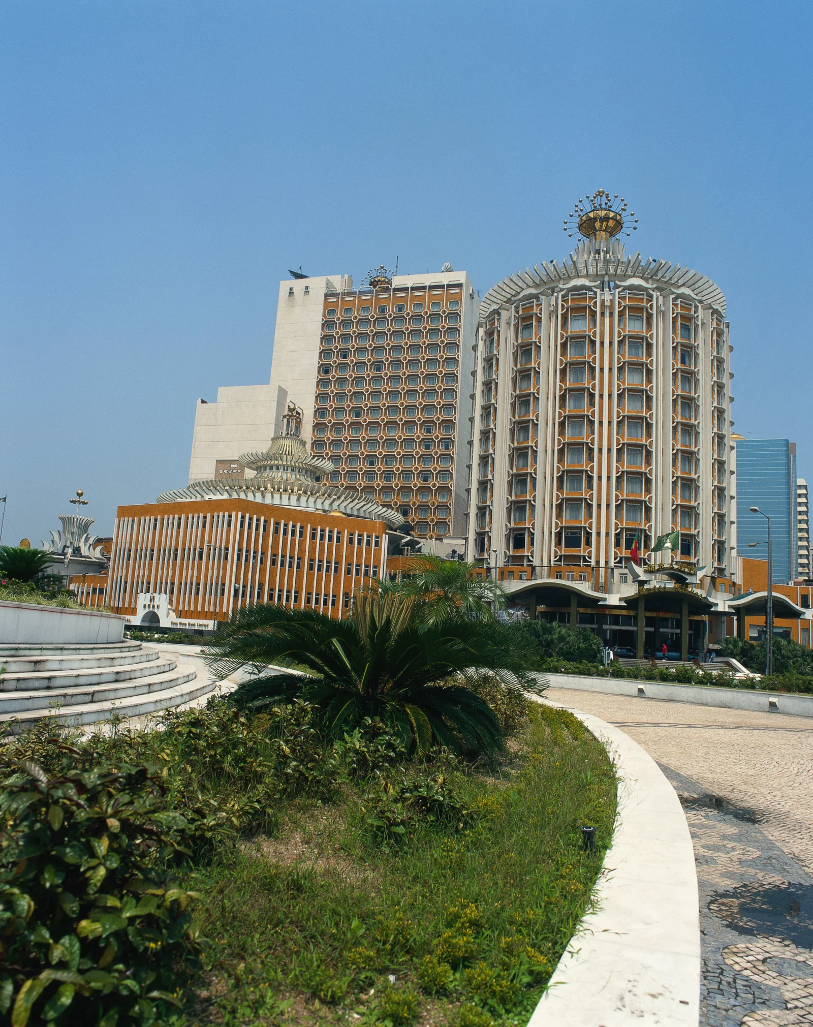 蓝天下的现代城市建筑群坐落在绿植环绕的公园旁。