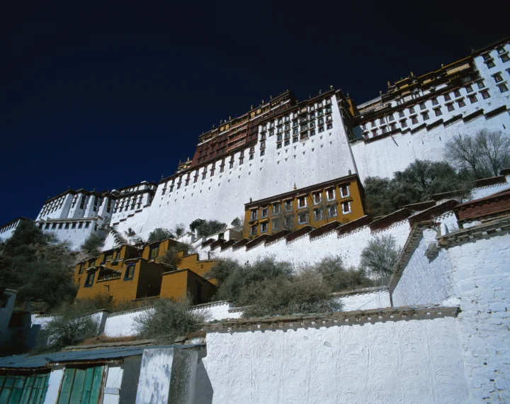 白色与金色建筑群沿山坡展开，背景是深蓝色天空。