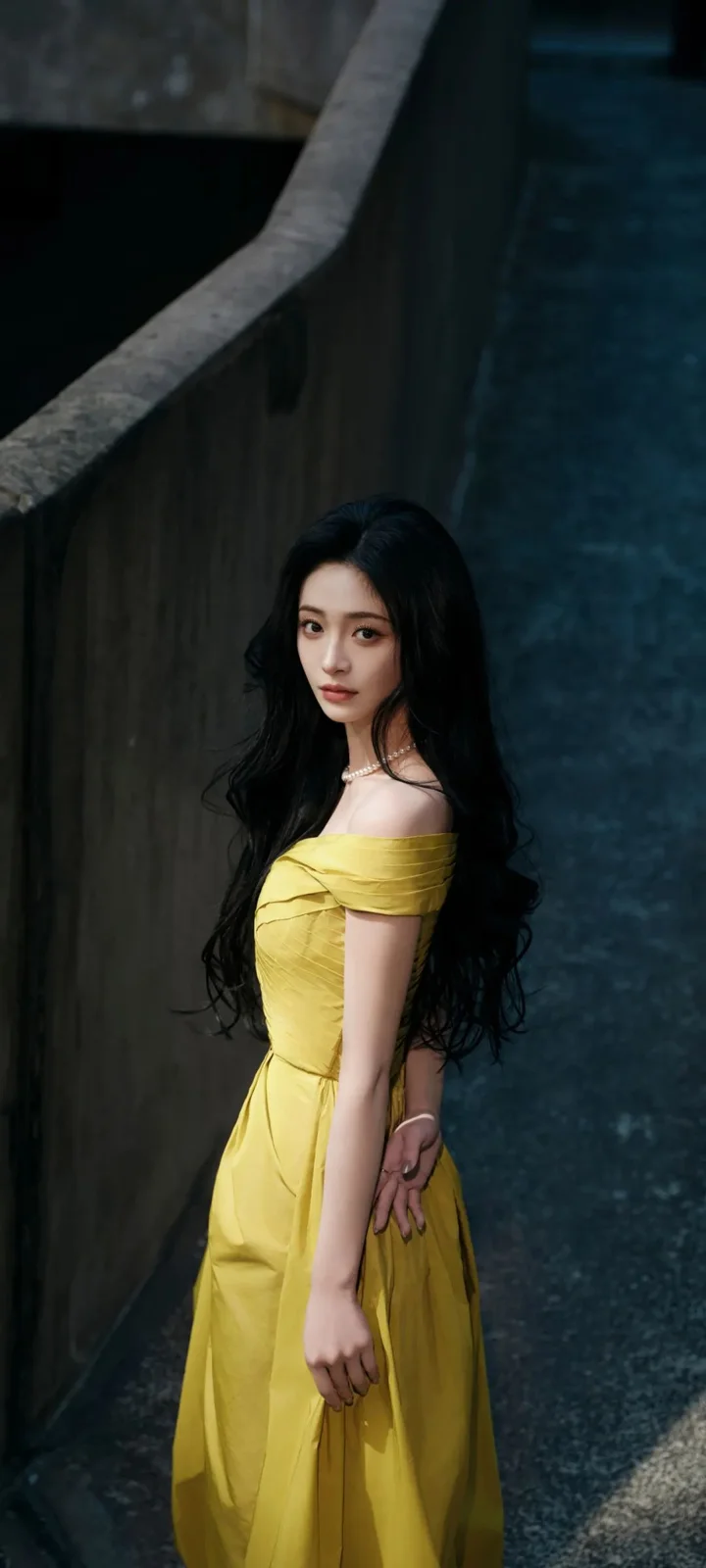 긴 머리의 여성이 노란 드레스를 입고 어두운 콘크리트 통로 옆에 서 있습니다.