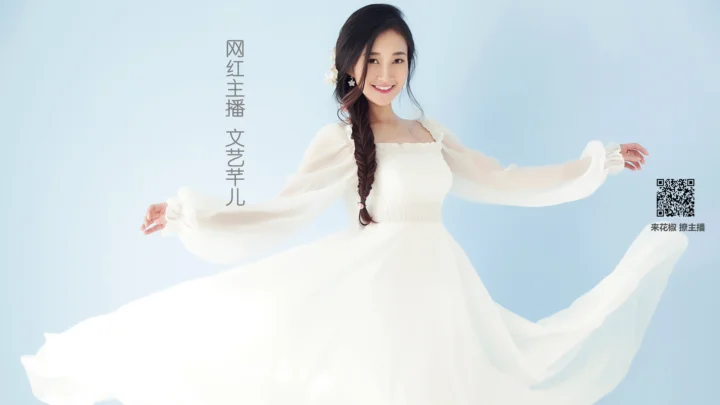 一名微笑的女子穿着白色飘逸长裙，站在浅蓝色背景前。