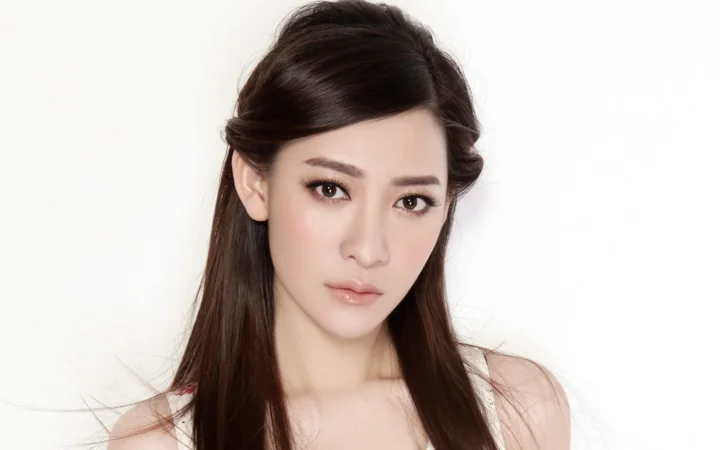 一名长发女性在白色背景前进行 studio 肖像拍摄。