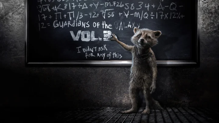 数式や文字で埋め尽くされた黒板の前で、アライグマが前足を上げて文字に触れています。