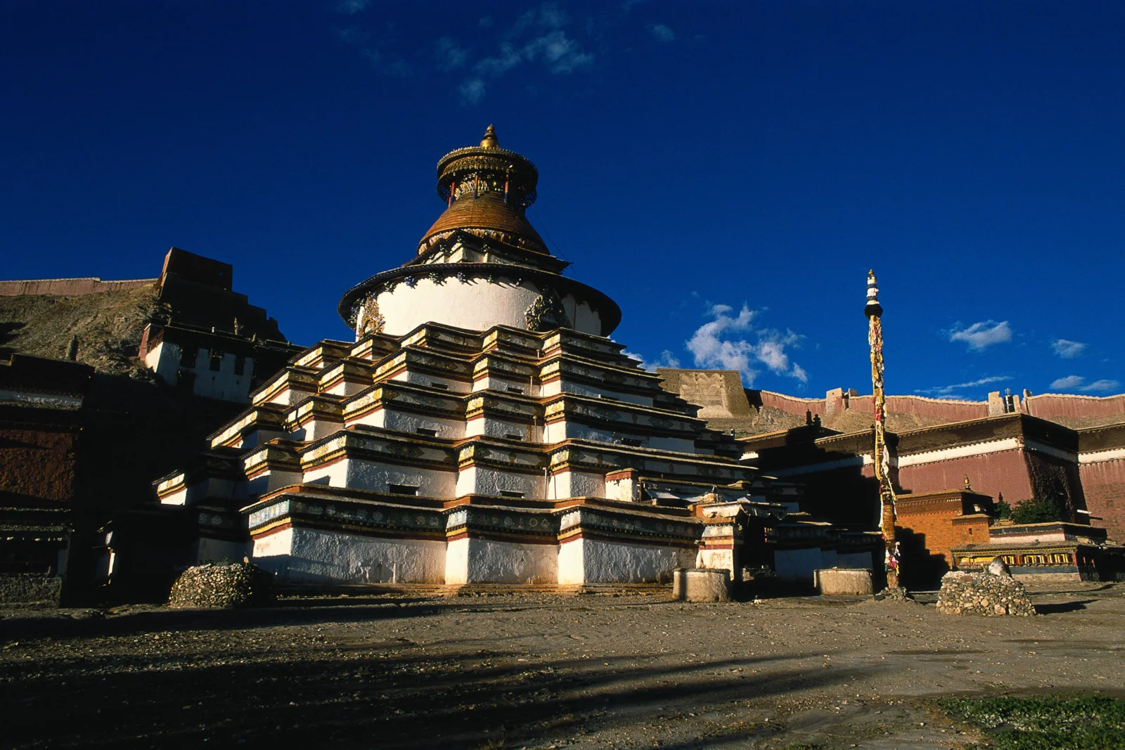 阳光下的古老寺院建筑坐落在深蓝天空前。