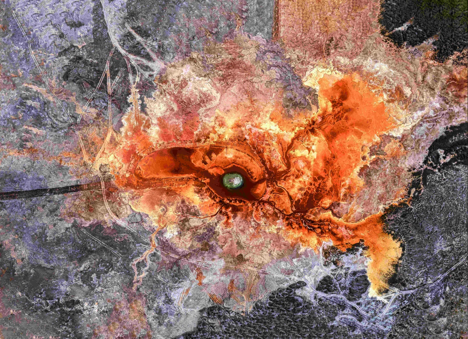 航拍视角展现橙红色矿物沉积环绕的深色地热泉池。