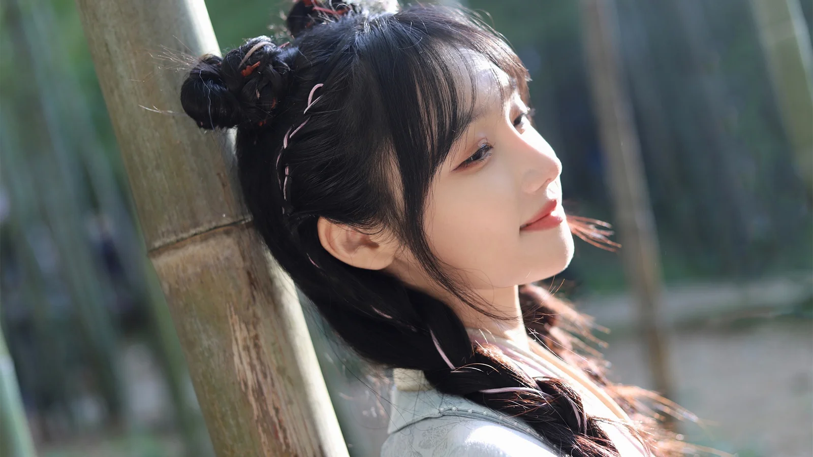 一位女性在竹林旁迎着阳光呈现侧脸人像。