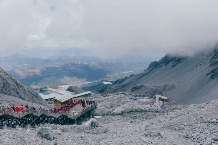 云雾笼罩的高山岩坡延伸至远方，山间设有观景平台和栈道。