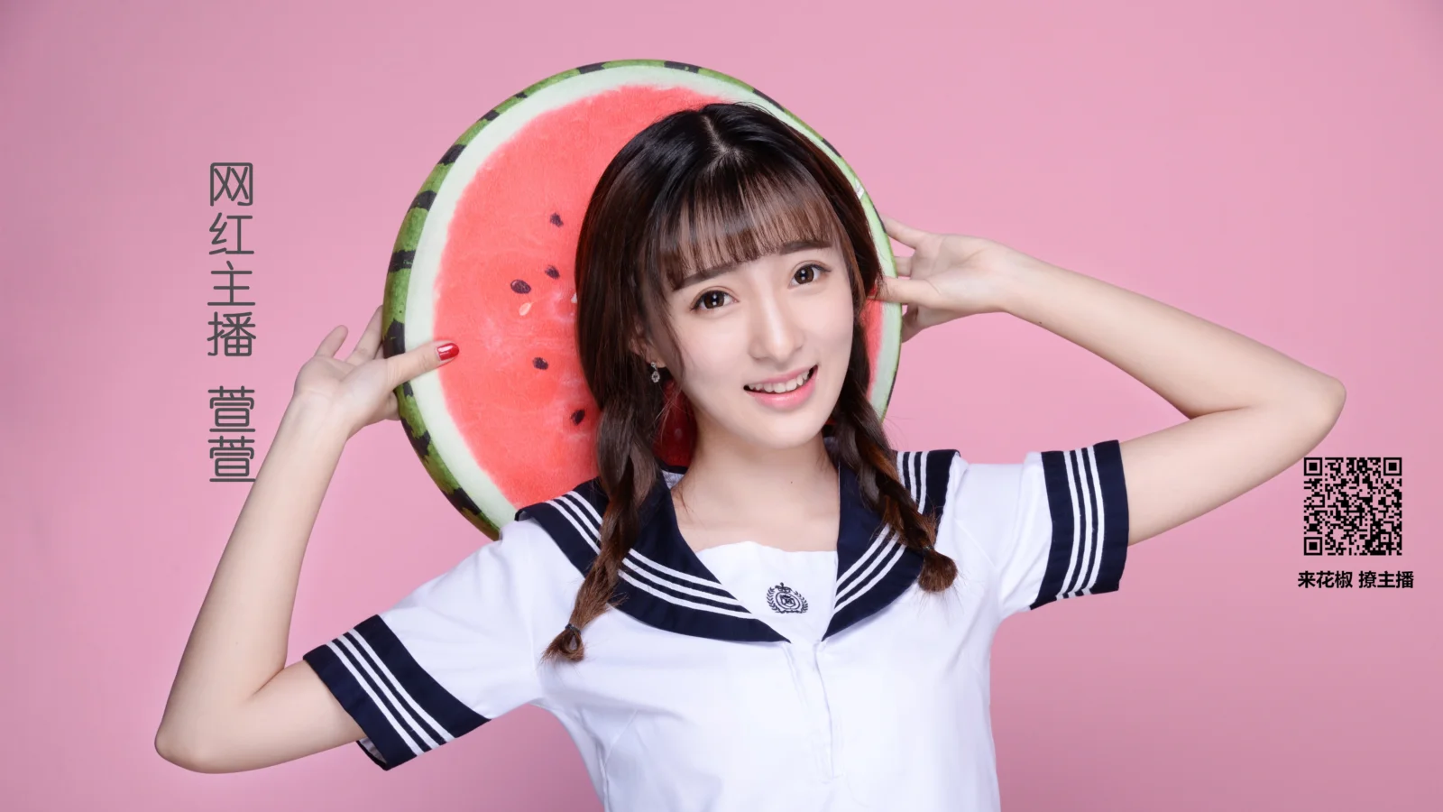 一名女子身穿白色水手风上衣，手托一片西瓜站在粉色背景前。