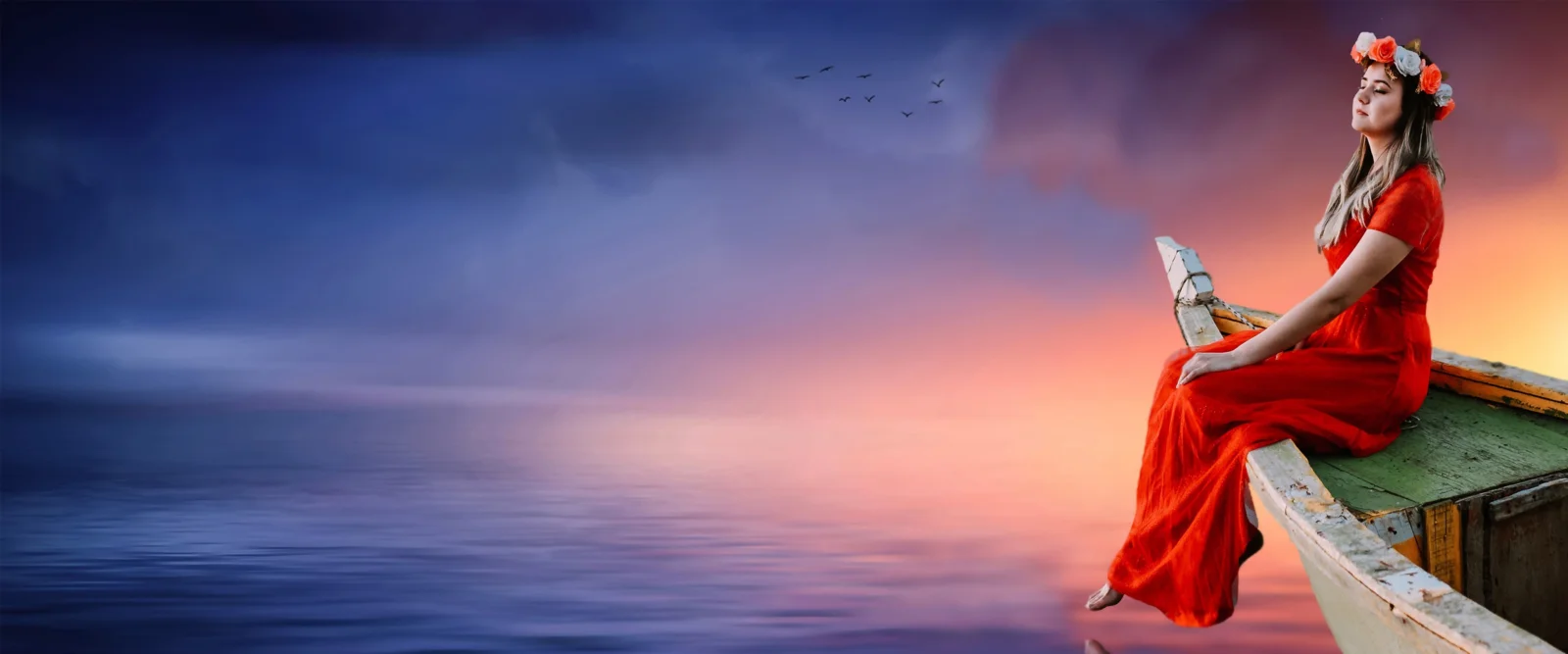 一名身穿红裙的女子坐在船边，远处是平静海面与绚丽的落日天空。