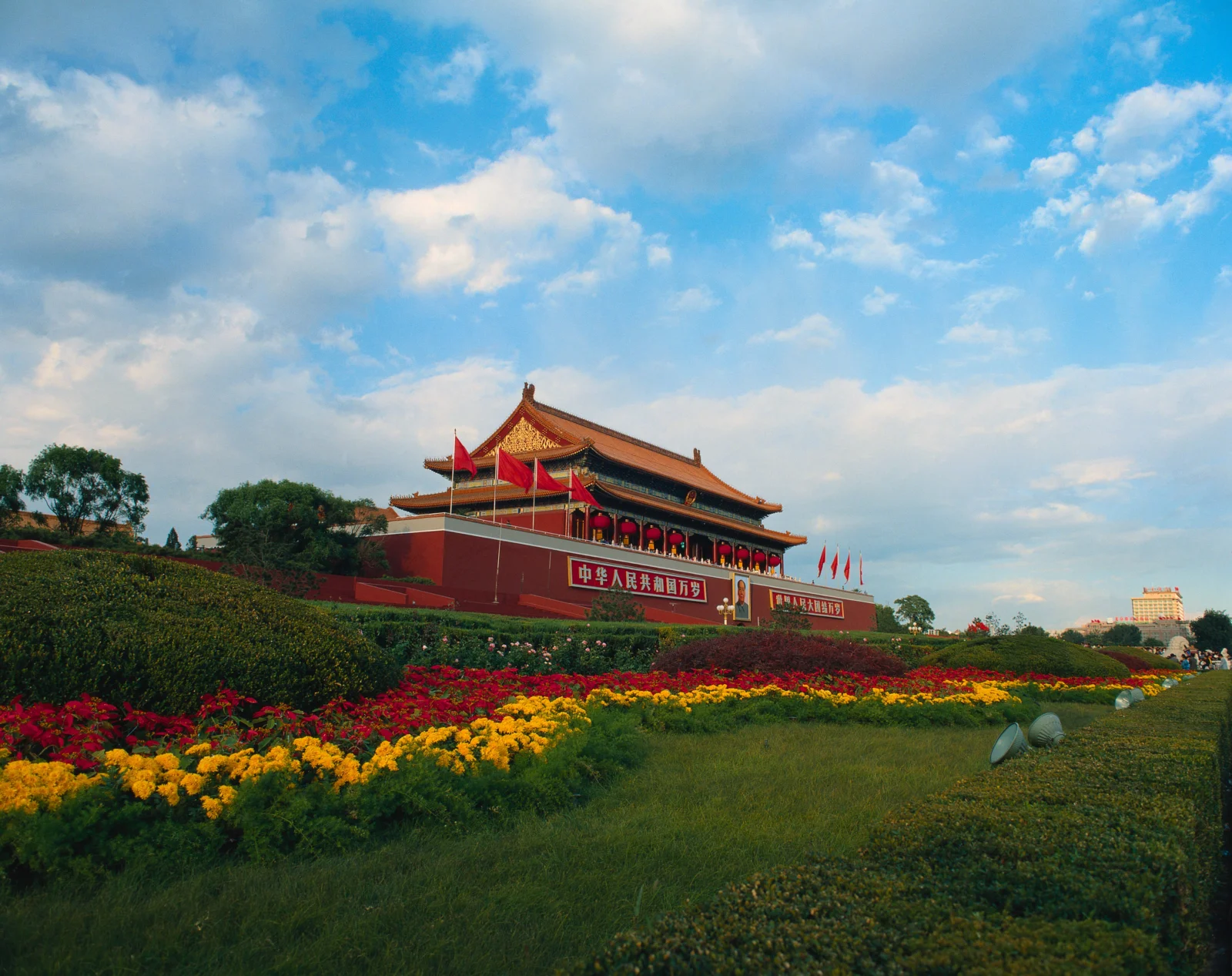 蓝天下，一座中式地标建筑坐落在繁花盛开的园林之间。