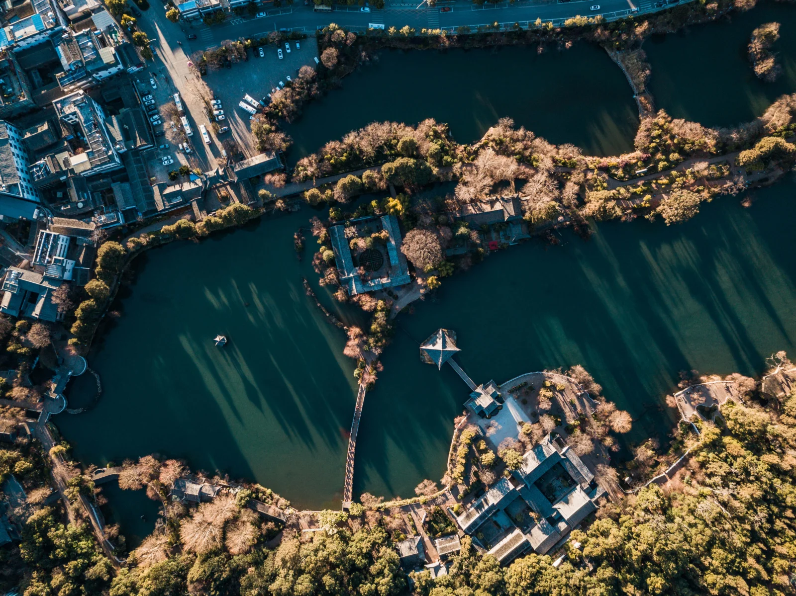 木々や建物、橋に囲まれた湖畔公園を上空から見下ろした風景です。