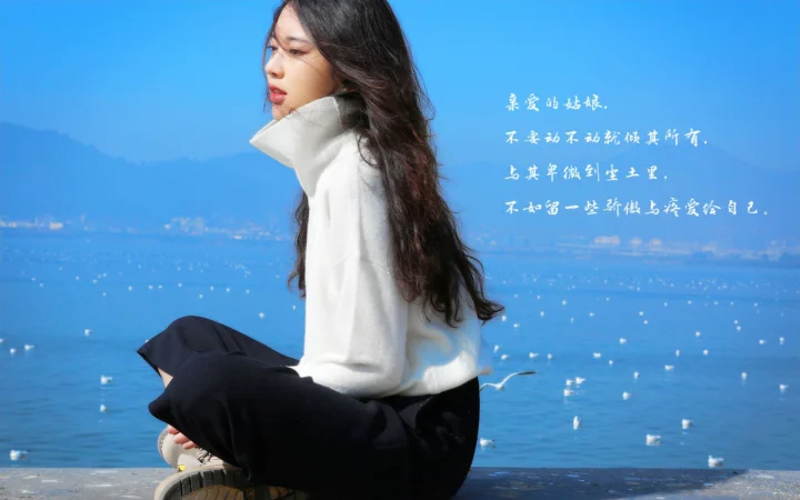 一名身穿白色毛衣的成年女子坐在蓝色湖水旁，远处可见山峦，画面右侧有白色文字。
