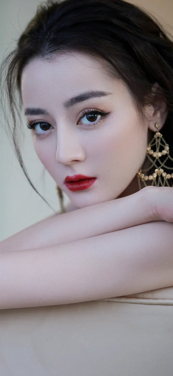 一位成年女性以近距离侧脸姿态面对镜头，佩戴华丽耳饰，背景简洁柔和。