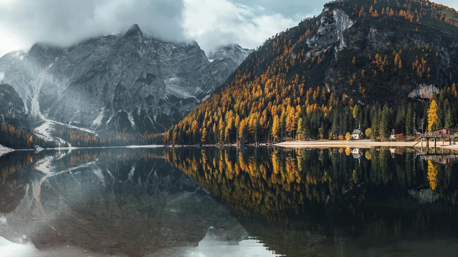 群山、秋色森林与宁静湖面倒映在一起，构成开阔的自然风景。