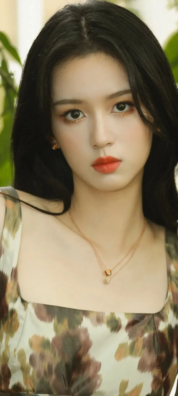 一名黑发女子身穿花卉图案服装，面对镜头呈现清晰的人像特写。