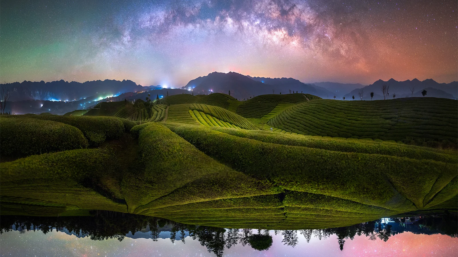 夜空中的银河映照着起伏的茶园、远山与水面倒影。