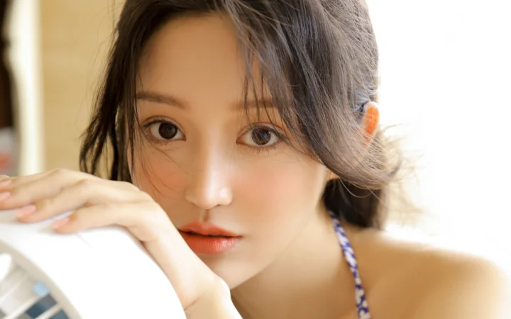一位棕色头发的女性在明亮自然光下进行近距离肖像拍摄。