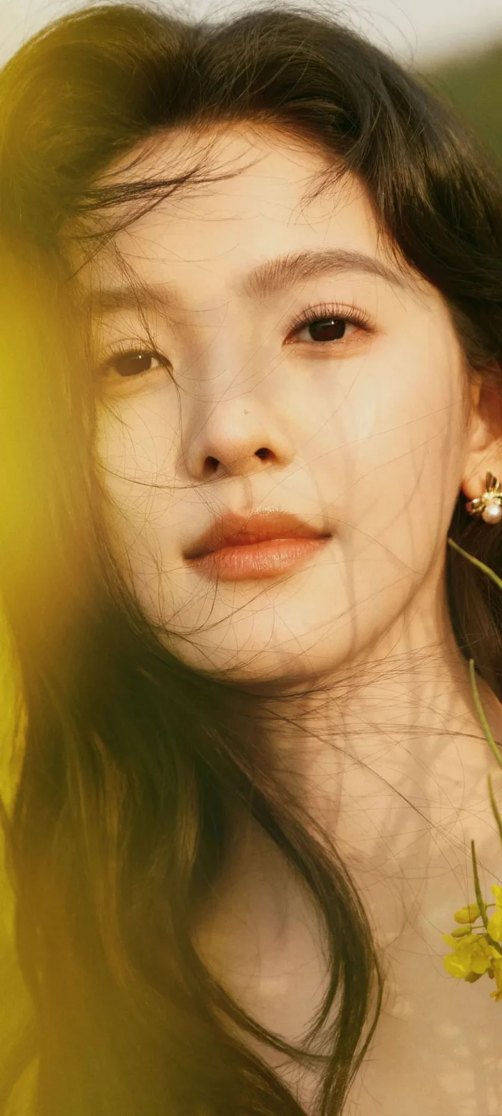 一位成年女性的近距离肖像，柔和的自然光映照着她的面容和长发。