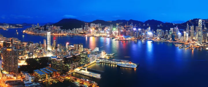 夜幕下的海港城市燈火映照在平靜水面上。