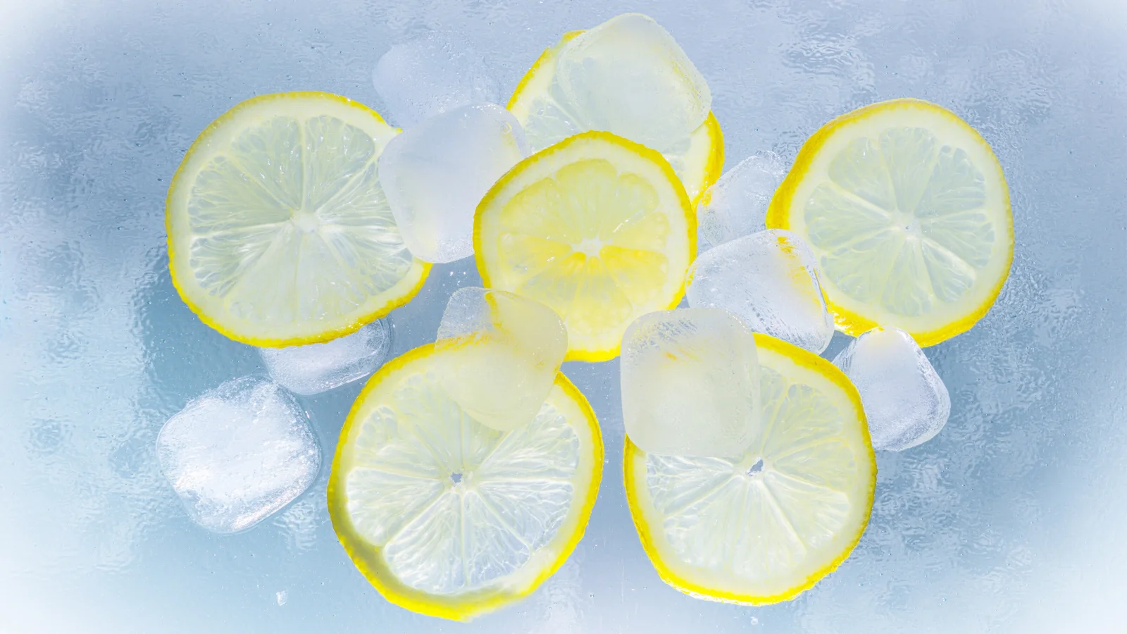 薄切りレモンと半透明の氷が淡い青色の氷の表面に並んでいる。