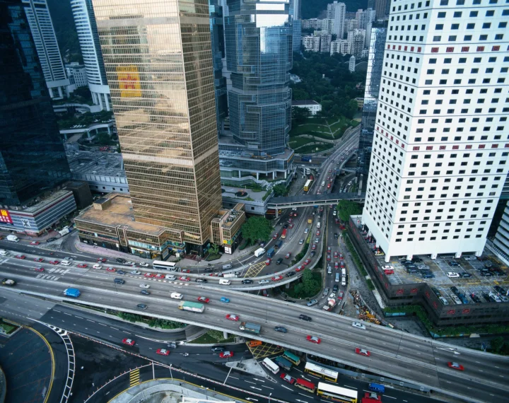 俯瞰城市高架道路、车流和密集摩天大楼组成的现代都市景观。