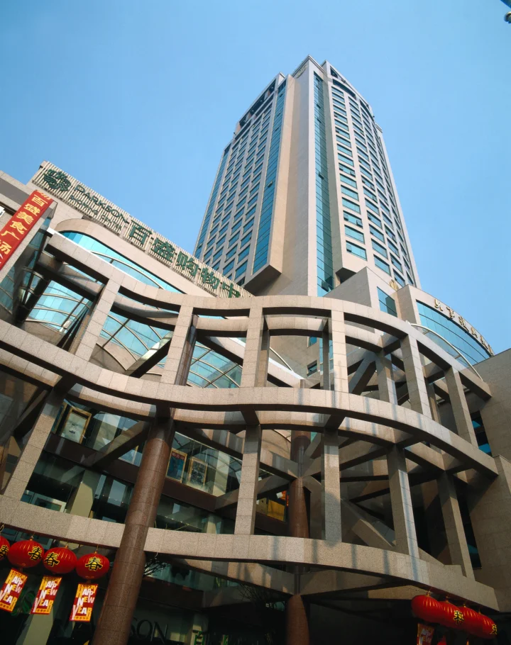 蓝天下，一座高层建筑从仰视角度延伸至画面上方。
