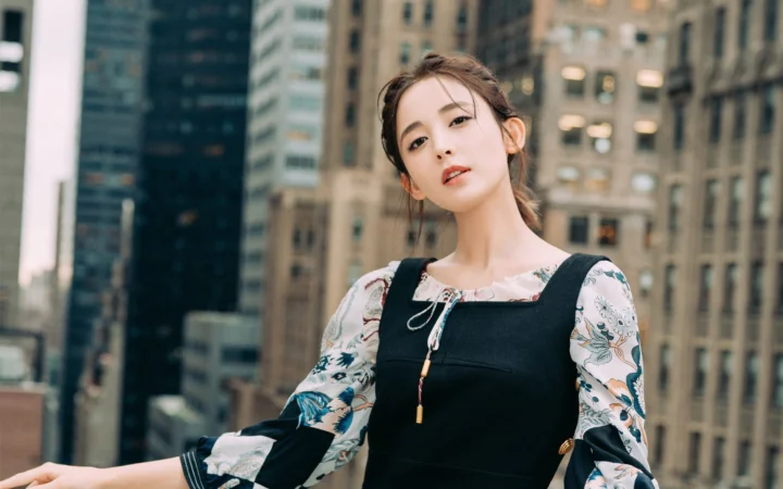 一名女性站在高楼林立的城市建筑前。