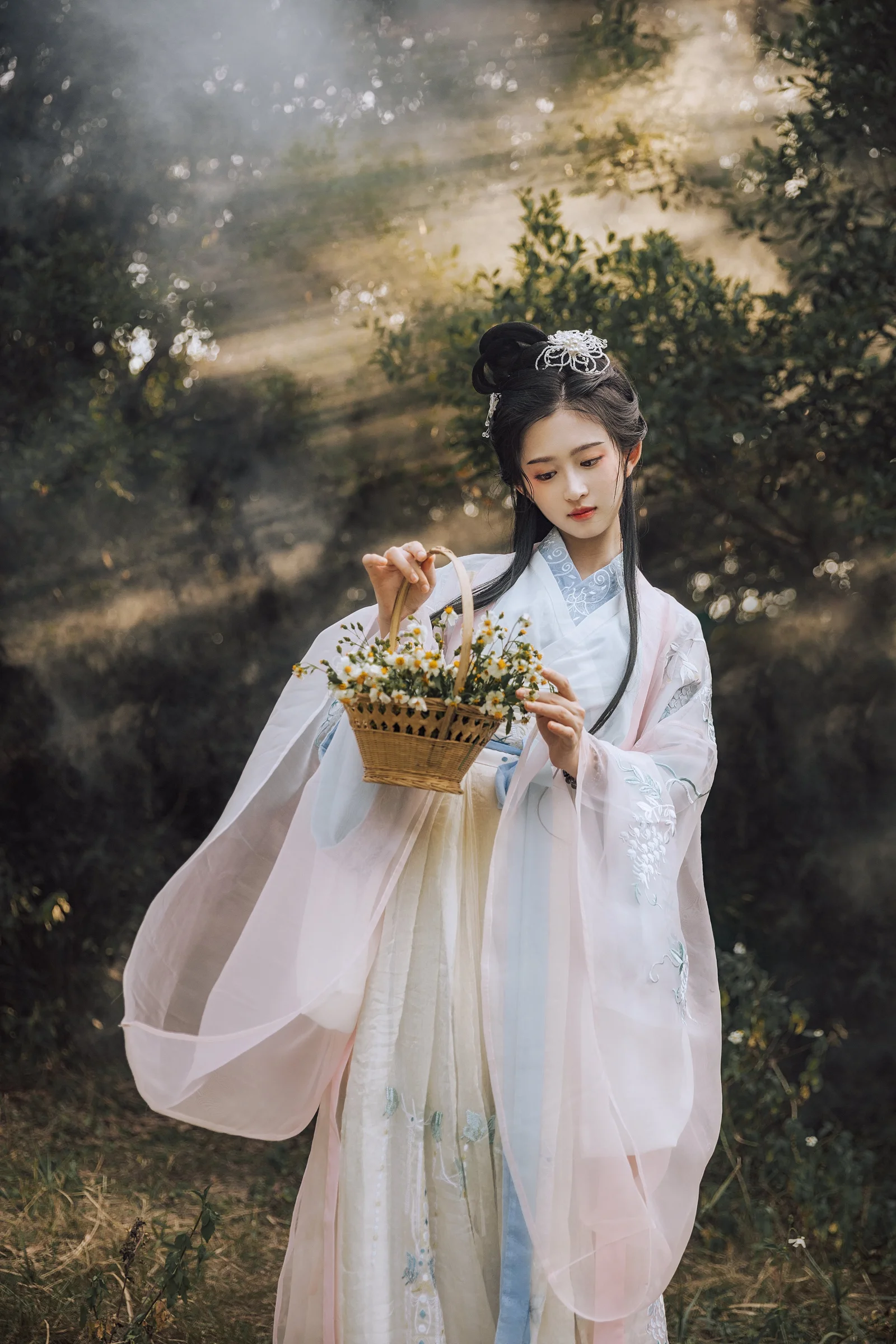 一位身穿浅色传统服饰的女子站在森林中，手提装满小花的篮子。