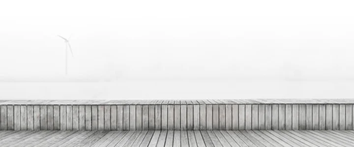 灰色木板状墙面与平台延伸在明亮的白色天空下，构成简洁的极简画面。