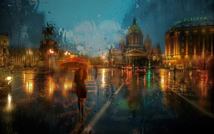 雨水覆盖的城市街道映照着灯光与建筑，远处可见撑伞行人。