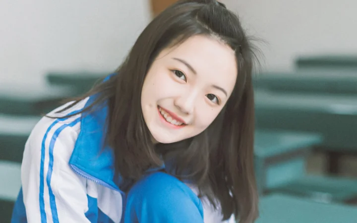 一名穿蓝色外套的女性对着镜头微笑。