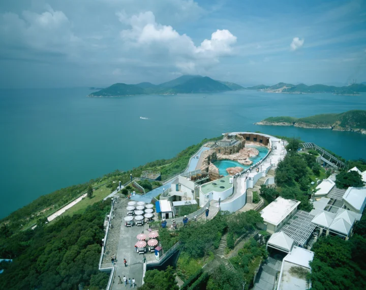 俯瞰视角展现了湛蓝海湾、远处群山和临海建筑群。