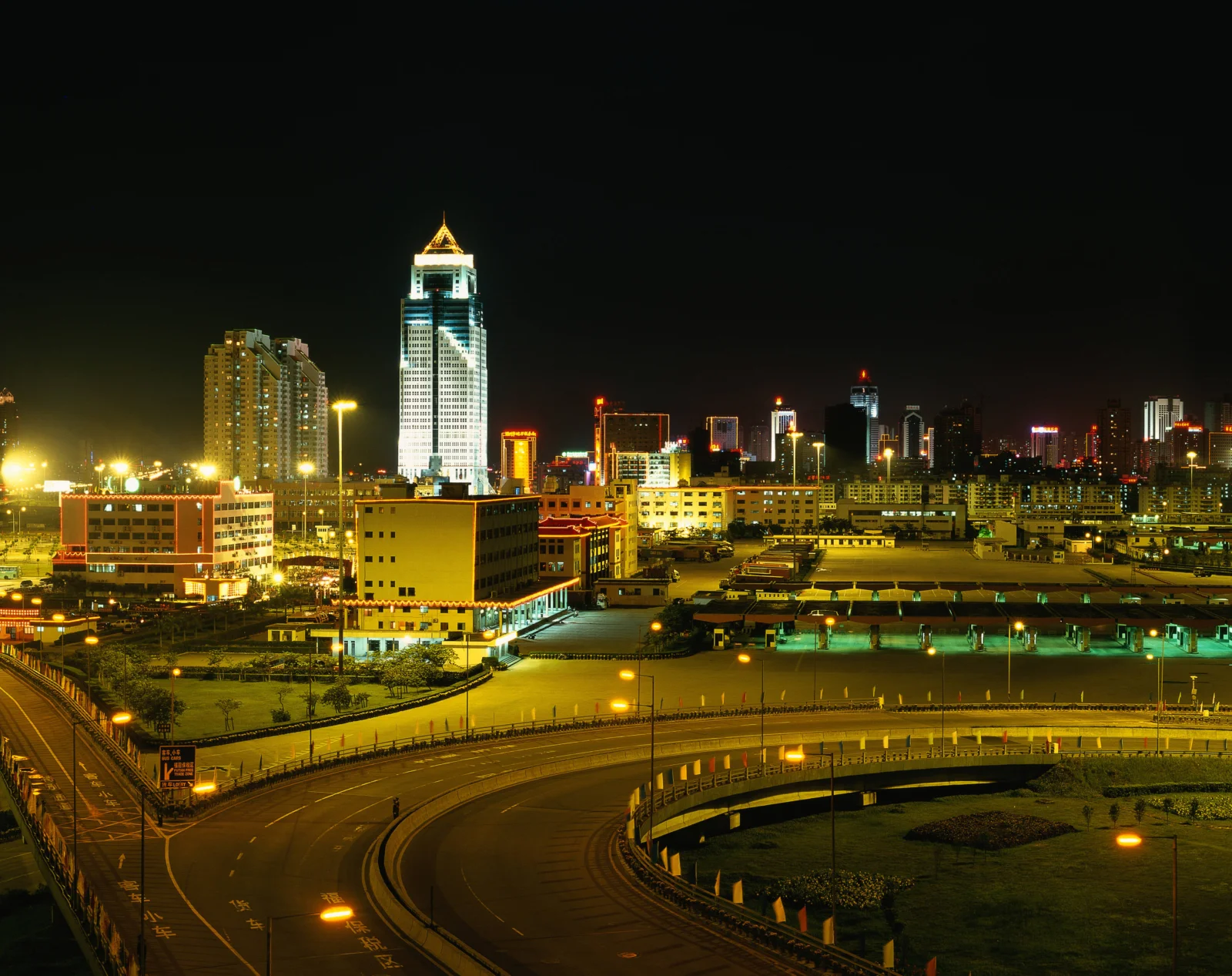 夜色中的城市建筑群、灯光与弧形立交桥构成一幅都市夜景。
