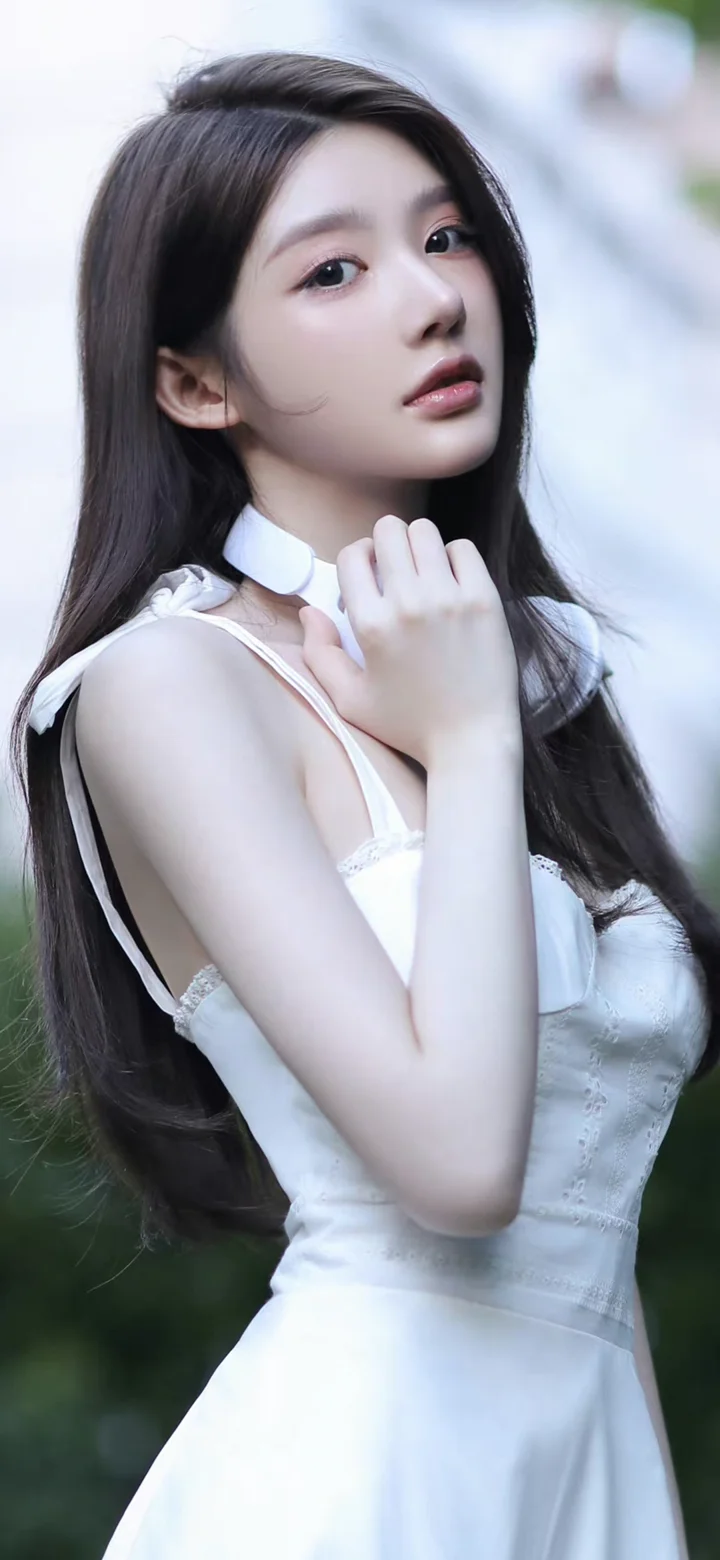 一位长发女性身穿白色连衣裙，在柔和的户外背景前回眸。