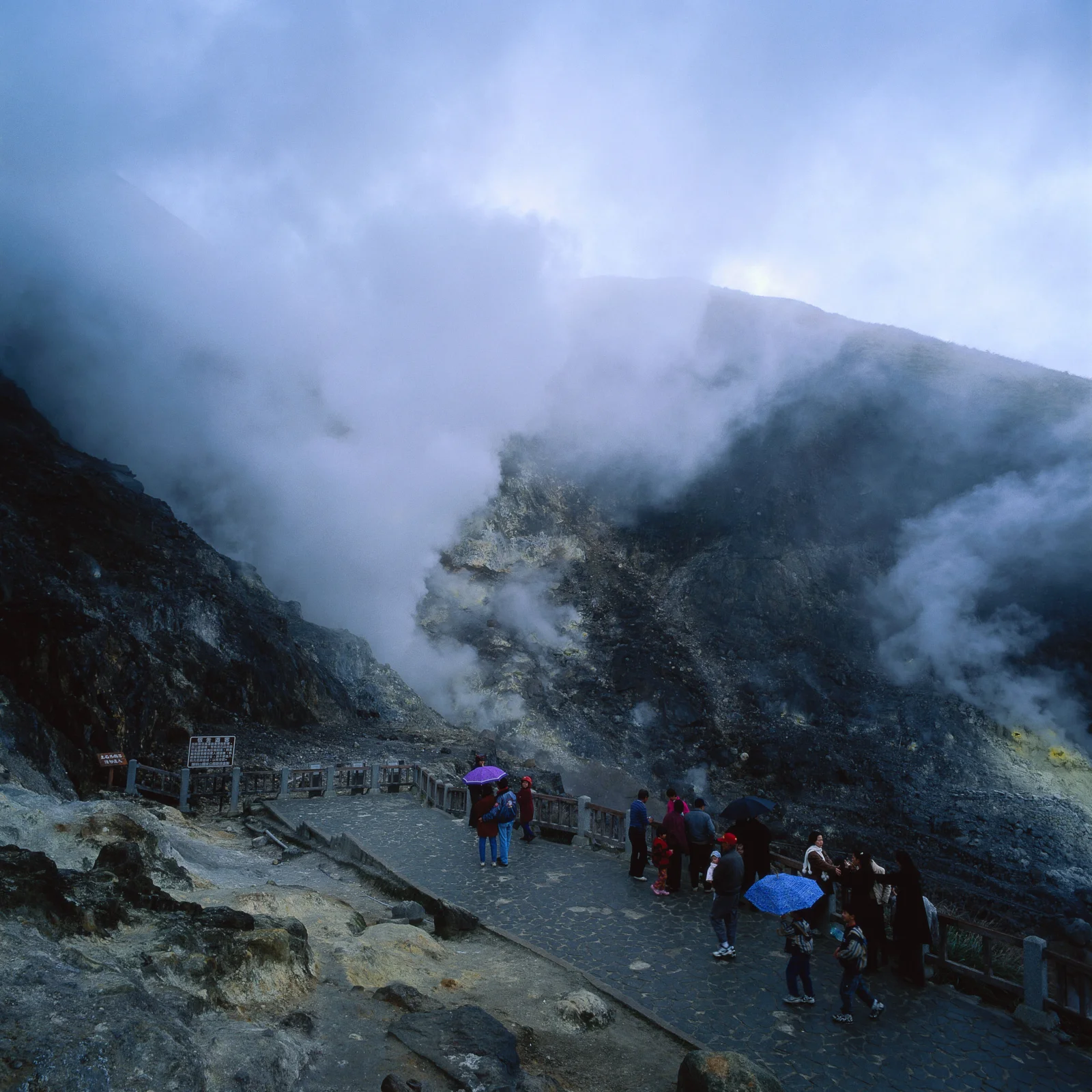 霧氣籠罩的山谷中，一條石板步道沿著陡峭山坡延伸。